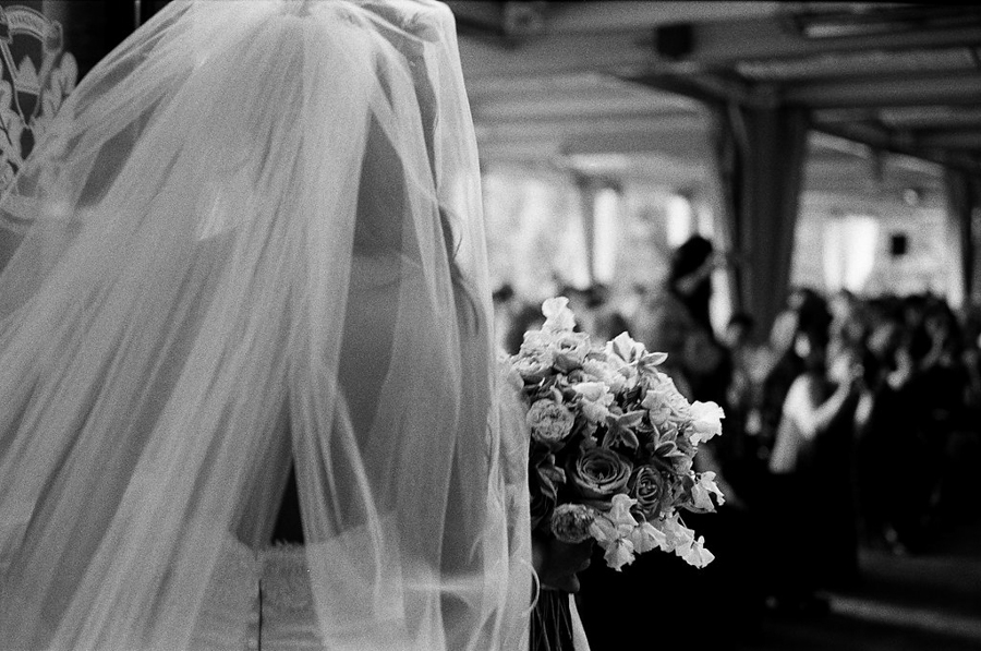 bride heading down isle in black and white